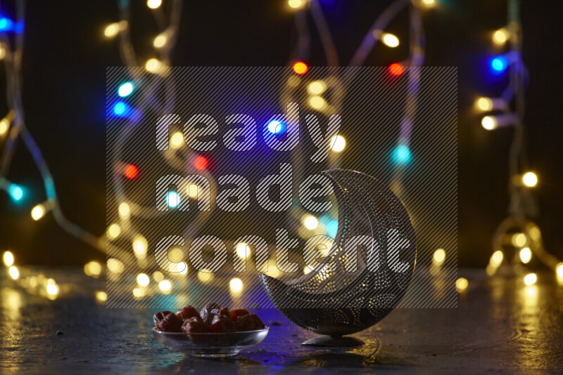 A traditional ramadan lantern surrounded by glowing fairy lights in a dark setup