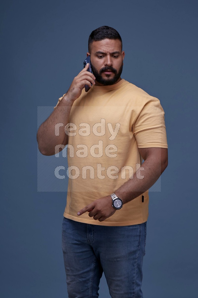 A man Calling on Blue Background wearing Orange T-shirt