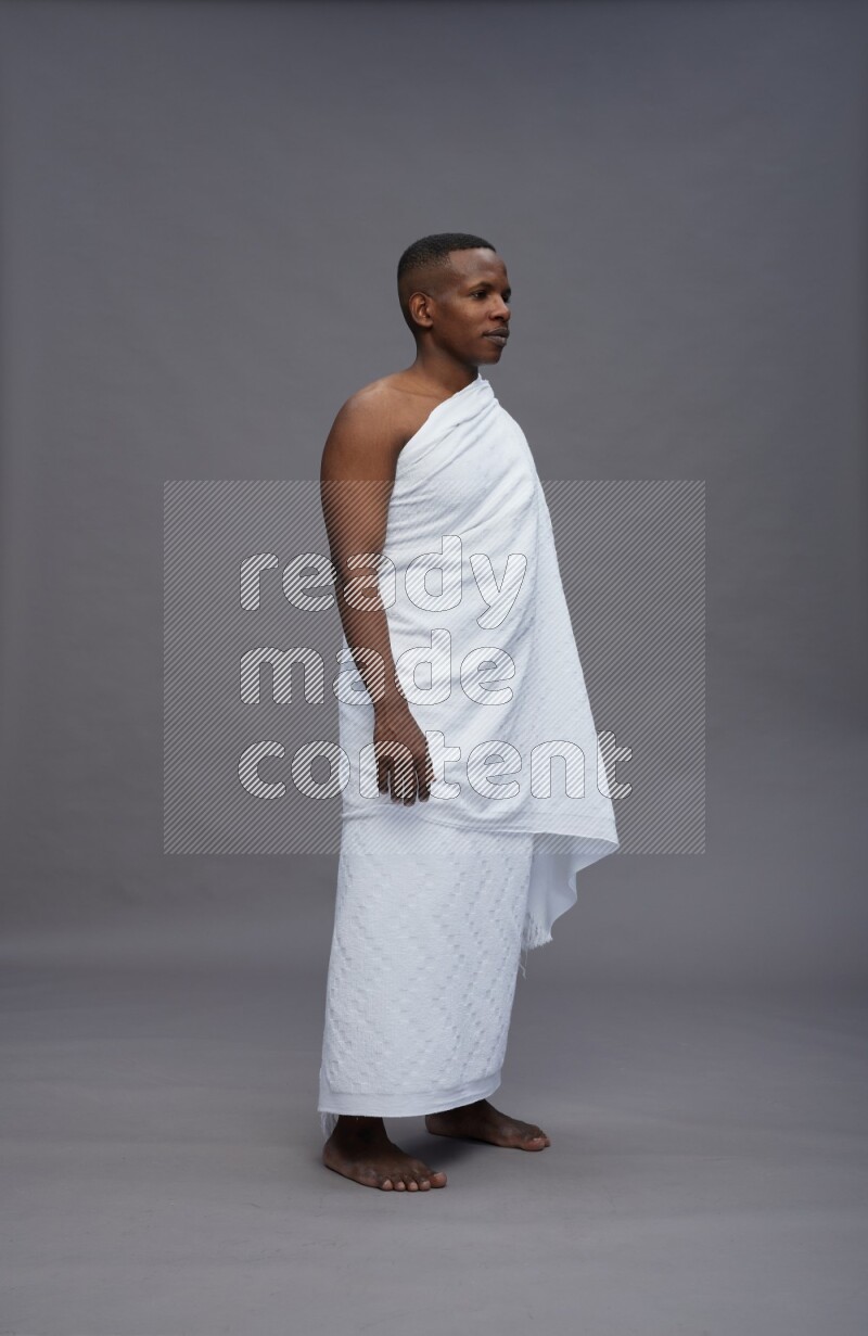 A man wearing Ehram Standing Interacting with the camera on gray background