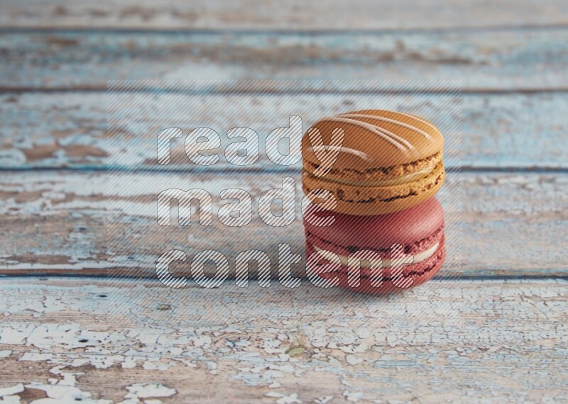 45º Shot of of two assorted Brown Irish Cream, and Red Velvet macarons on light blue background