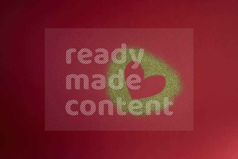 A heart drawn with gold glitter on red background