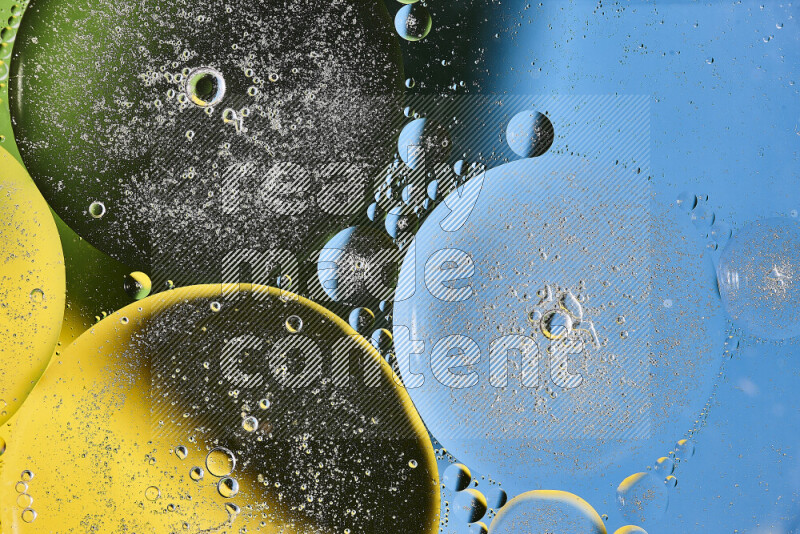 Close-ups of abstract oil bubbles on water surface in shades of yellow, green and blue