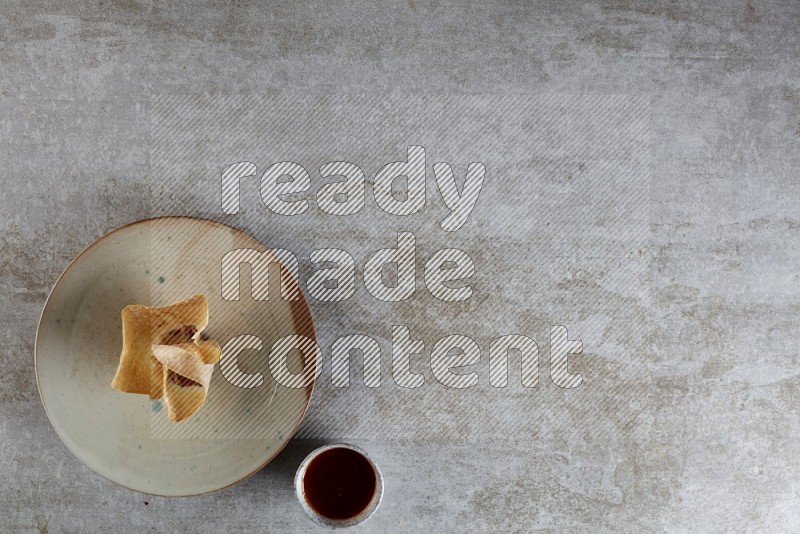 wonton cups with soy sauce ramkin on multi colored pottery on grey textured counter top