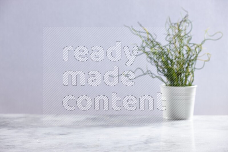 Artificial plant in white pot on grey marble background