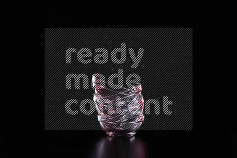 Glassware with rim light in red and white against black background