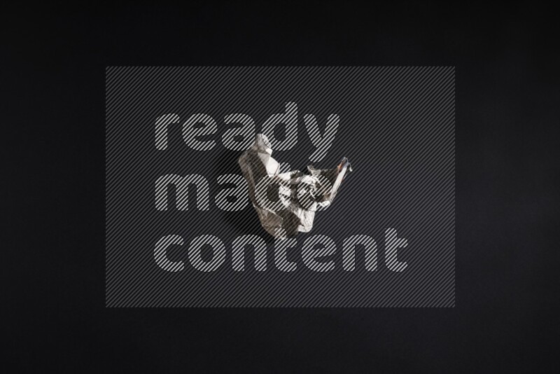 Crumpled newspaper sheet on black background