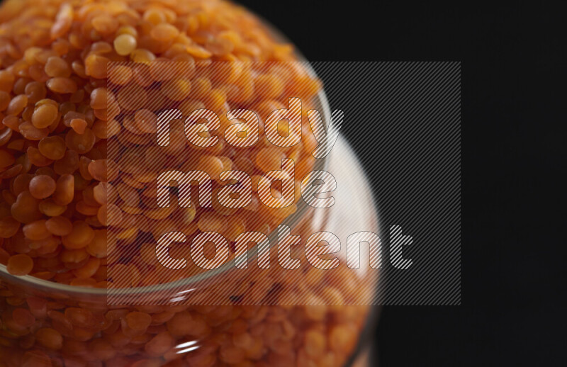 Lentils in a glass jar on black background