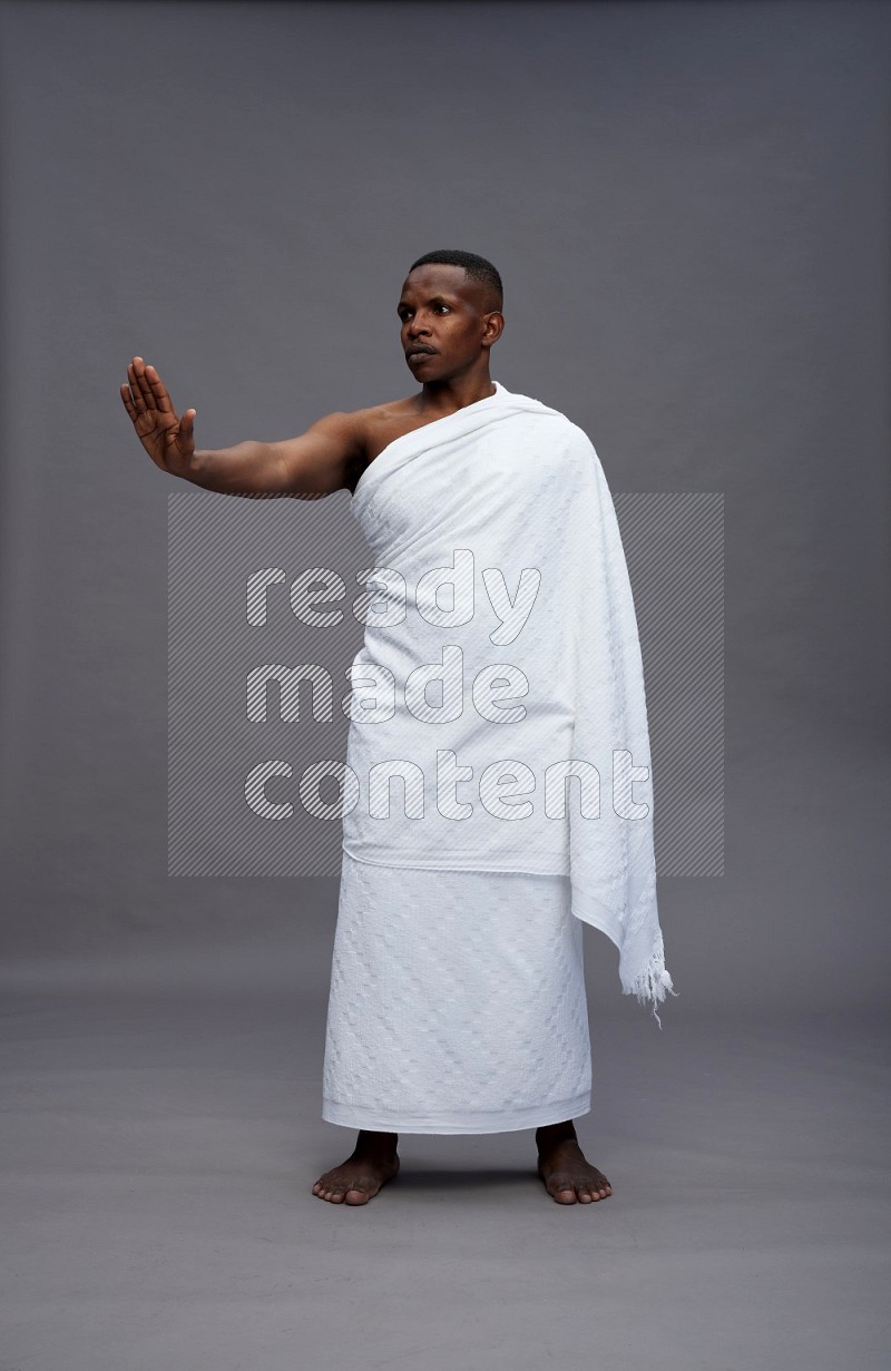 A man wearing Ehram Standing Interacting with the camera on gray background