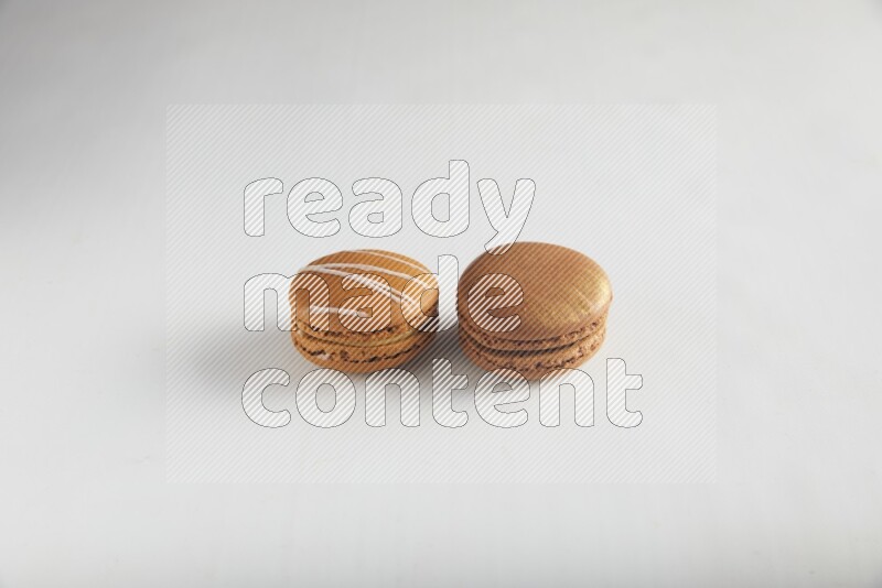 45º Shot of of two assorted Brown Irish Cream, and Brown Coffee macarons  on white background