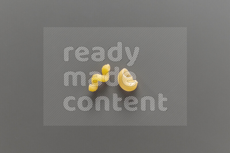Twist pasta with other types of pasta on grey background