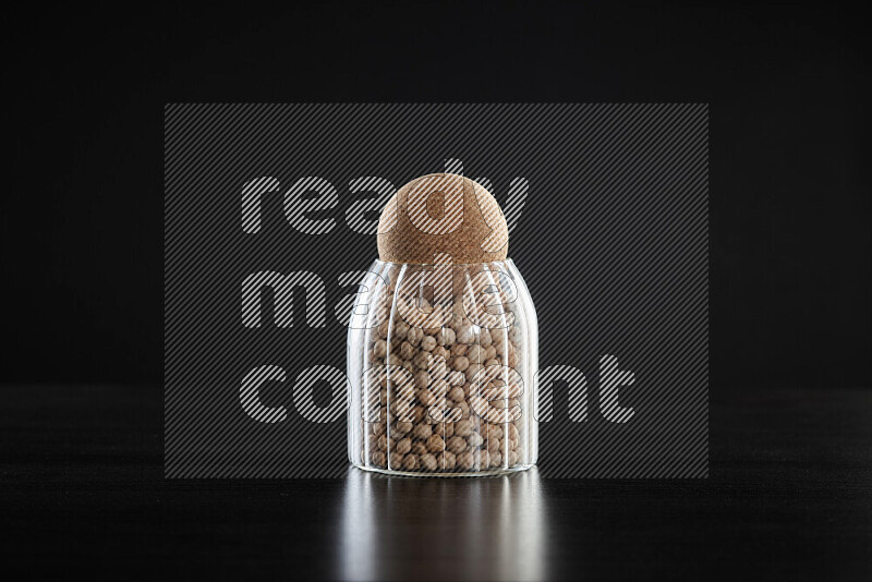 Chickpeas in a glass jar on black background