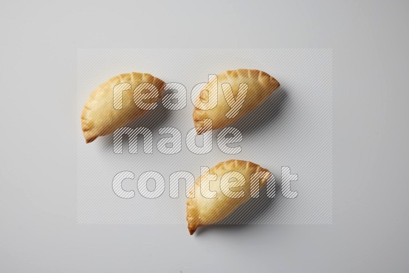 Three fried sambosa from a top angle on a white background