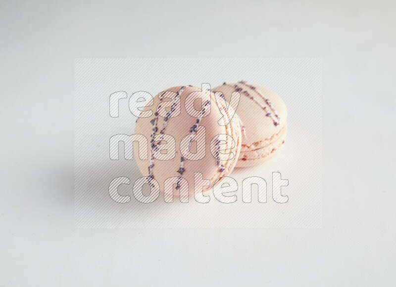 45º Shot of two pink orange blossom macarons on white background