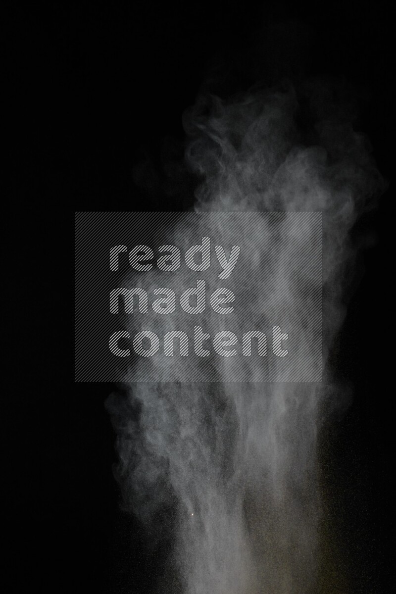 A side view of brown powder explosion on black background