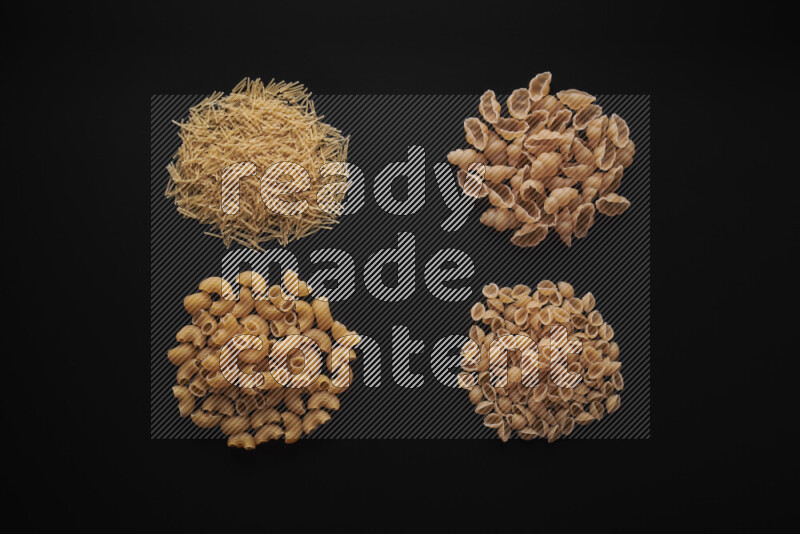 Different pasta types in bunches on black background
