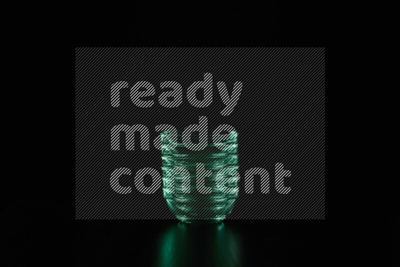 Glassware with rim light in green against black background