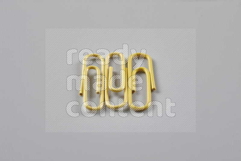 Yellow paper clips isolated on a grey background