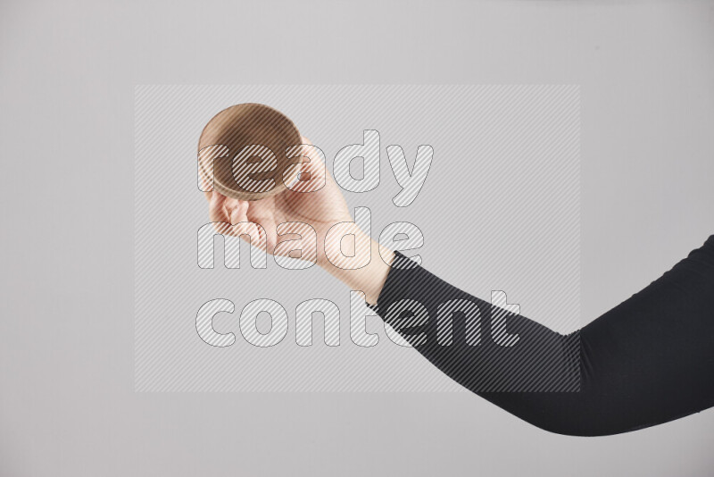 امرأة ترتدي عباءة سوداء تحمل أدوات خشبية مختلفة في أوضاع متعددة