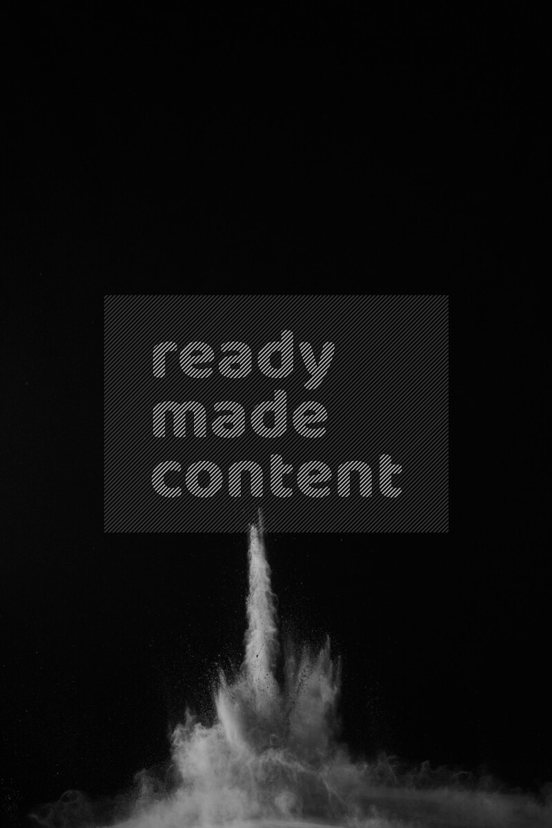 A side view of white powder explosion on black background