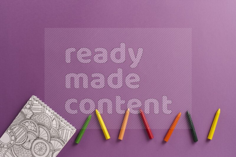 A coloring book with coloring pens on purple background