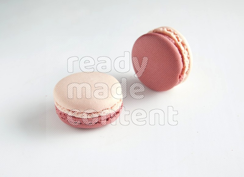 45º Shot of two Pink Litchi Raspberry macarons on white background