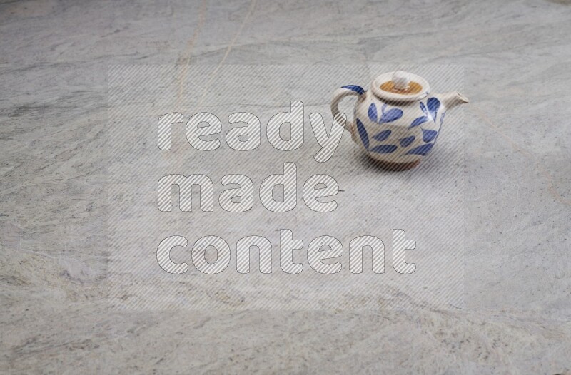 A pottery teapot on grey marble background