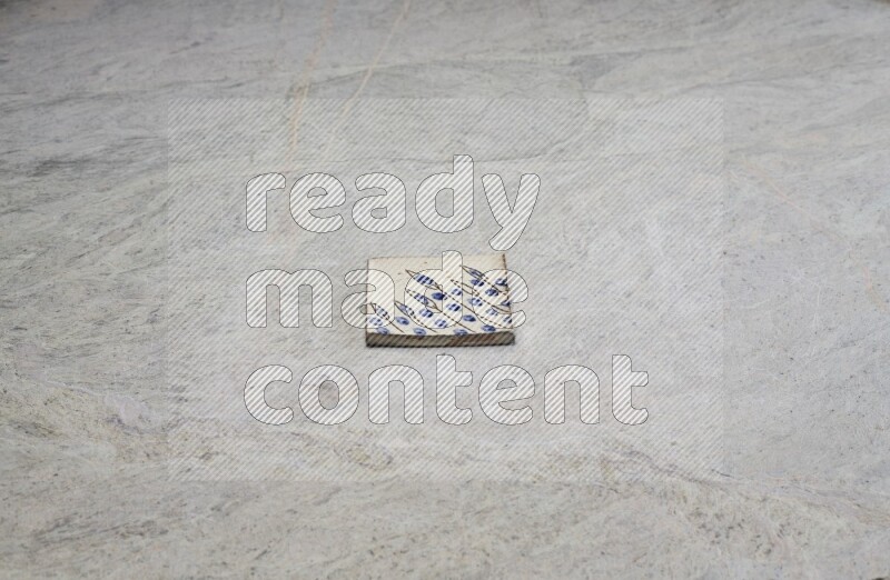 Top view shot of a pottery coaster\ tile on beige marble flooring