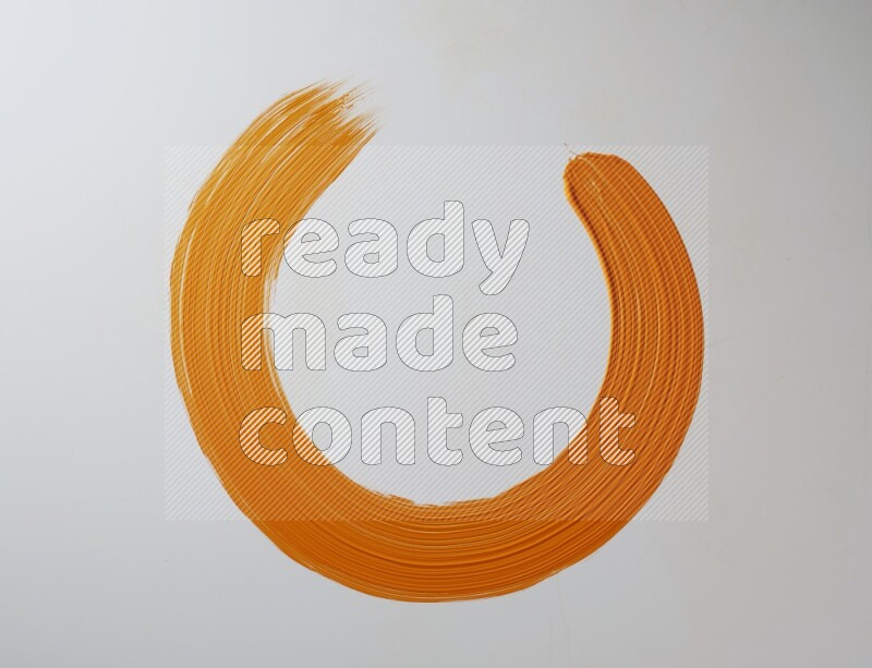 An orange circular painting brush stroke on white background