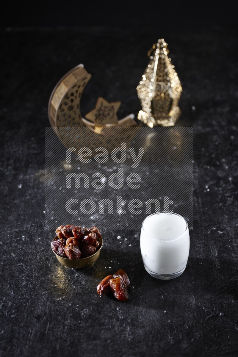 تمر في وعاء معدني مع مشروب السوبيا بجانب فوانيس ذهبية علي خلفية سوداء