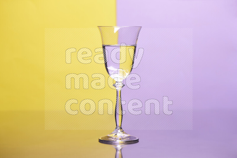 The image features a clear glassware filled with water, set against yellow and light purple background