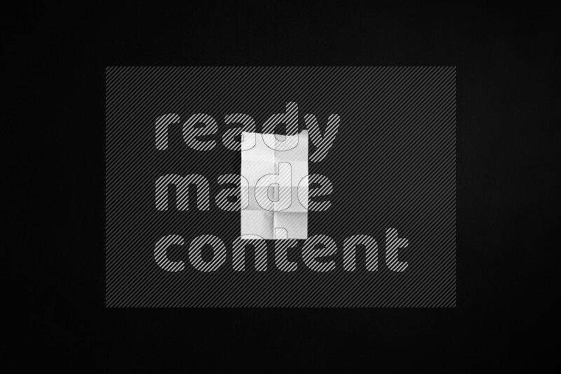 Folded notebook sheet on black background