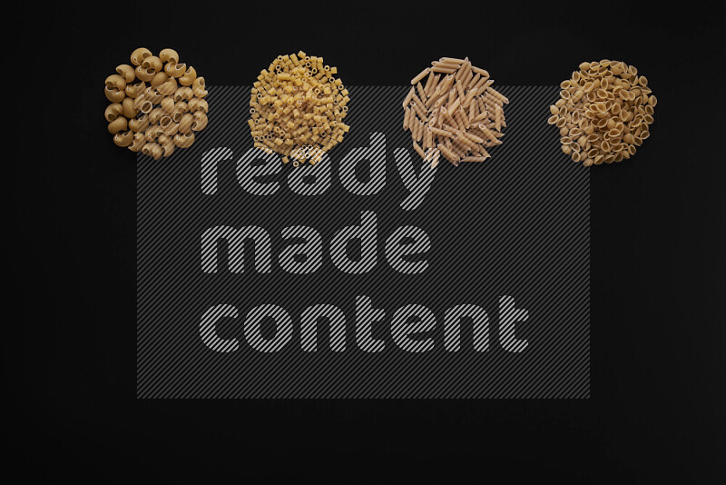 Different pasta types in 4 bunches on black background