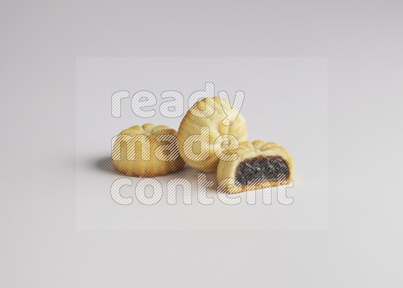 Three Pieces of Maamoul filled with date one of them is cut direct on white background