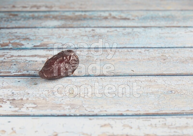 one madjoul date on a light blue wooden background