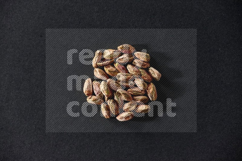 A bunch of peeled pistachios on a black background in different angles