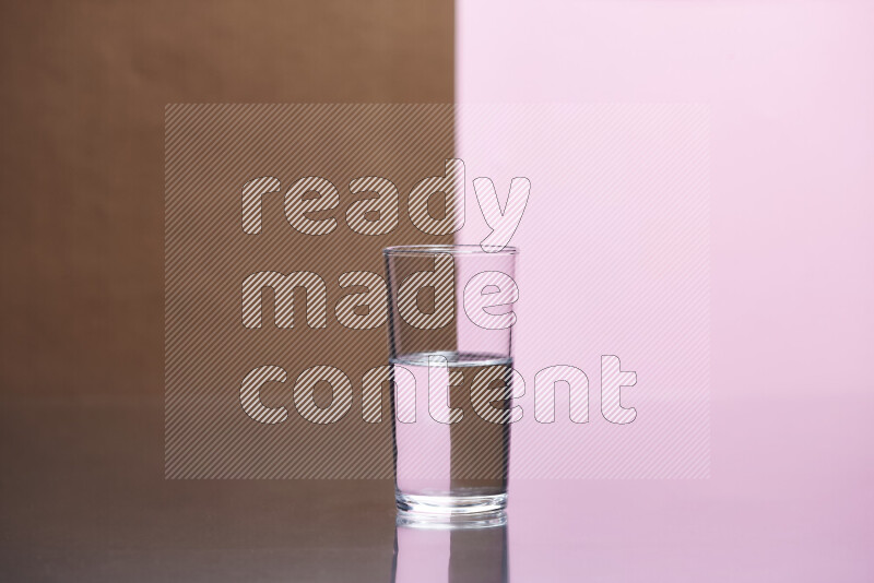 The image features a clear glassware filled with water, set against brown and rose background