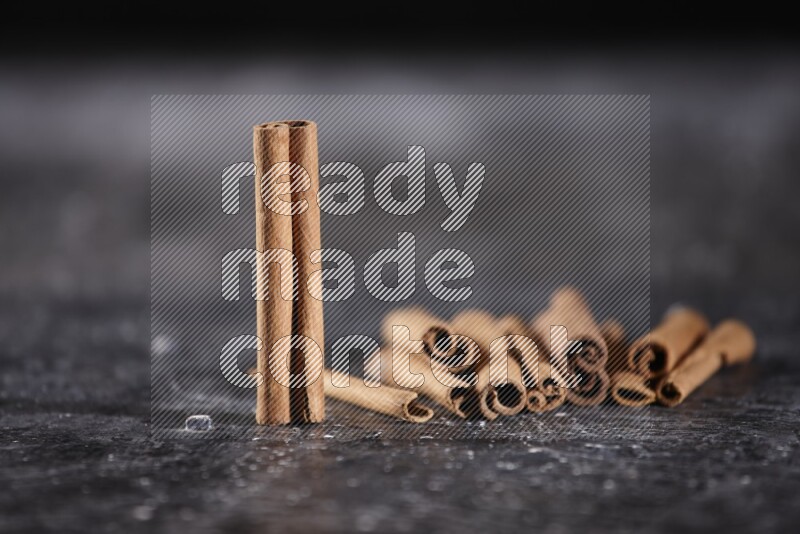 Cinnamon sticks on a textured black background
