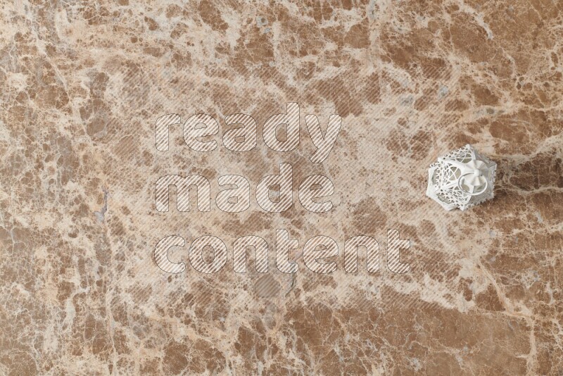 A candle lantern on beige marble background