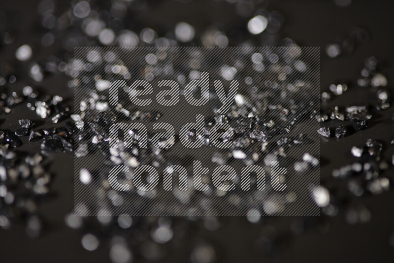 قطع زجاجية سوداء لامعة متناثرة على خلفية سوداء