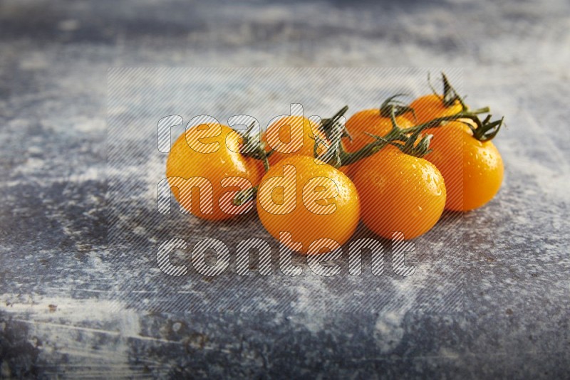 yellow cherry tomato vein on a textured rusty blue background 45 degree