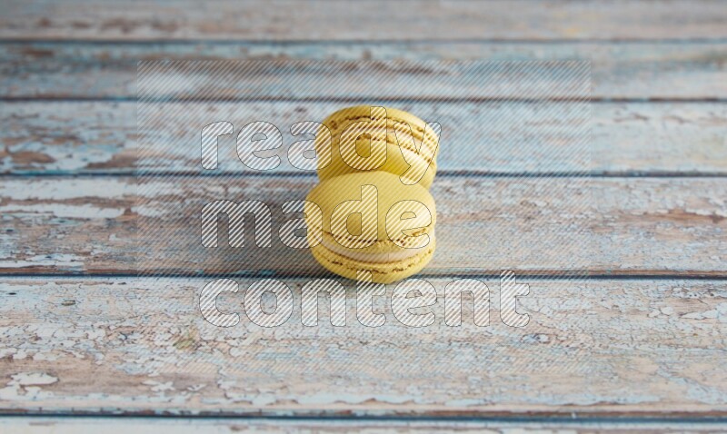 45º Shot of two Yellow Lime macarons on light blue wooden background