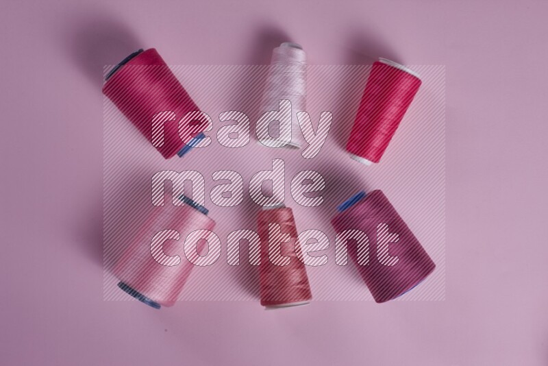 مجموعة من أدوات الخياطة والتفصيل زهرية اللون على خلفية زهرية