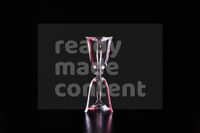 Glassware with rim light in red and white against black background