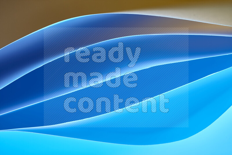 هذه الصورة تعرض تكوين فن الورق التجريدي مع منحنيات ورقية بتدرجات اللون الأزرق والبرتقالي المكونه بواسطة الضوء الملون