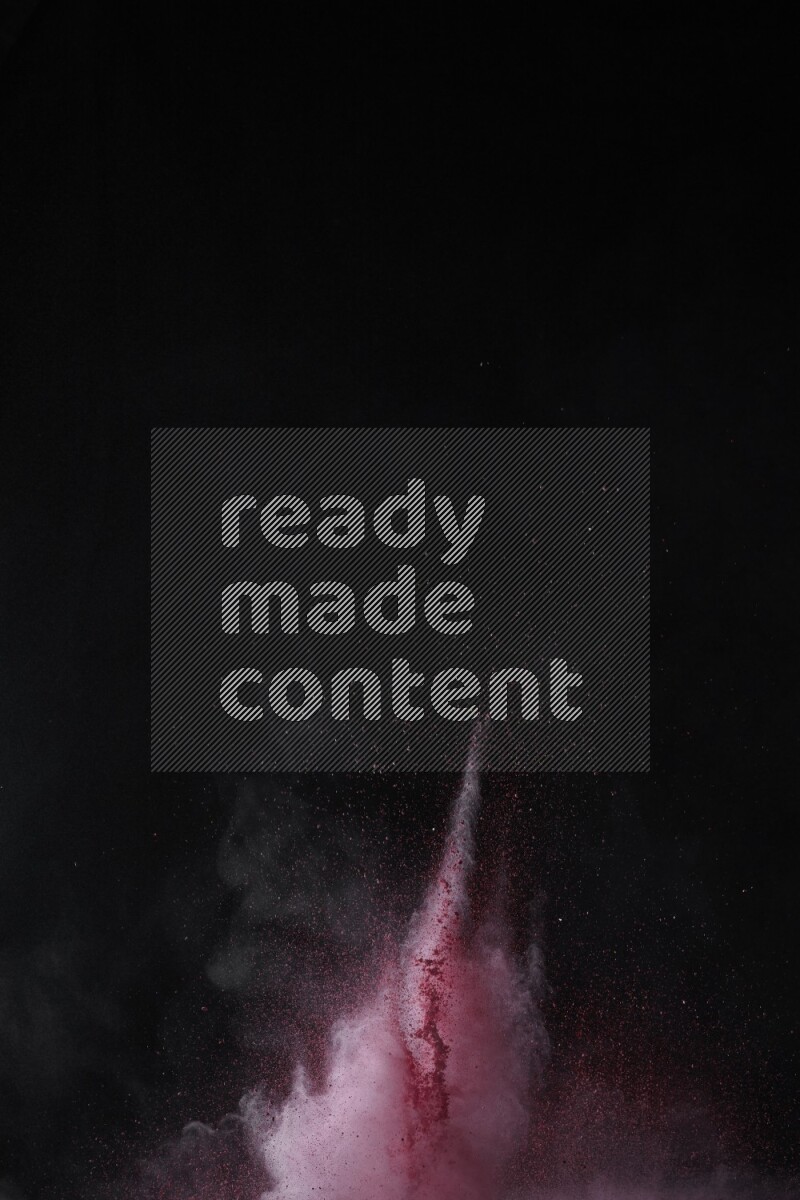 A side view of red powder explosion on black background