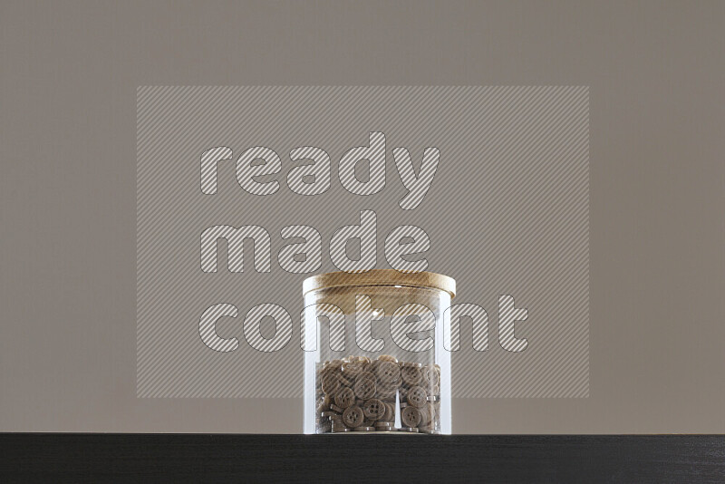 Buttons in a glass jar on black background