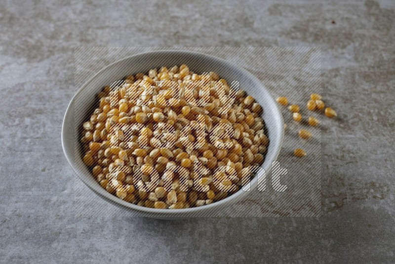 corn kernel in a gray ceramic bowl on a grey textured countertop