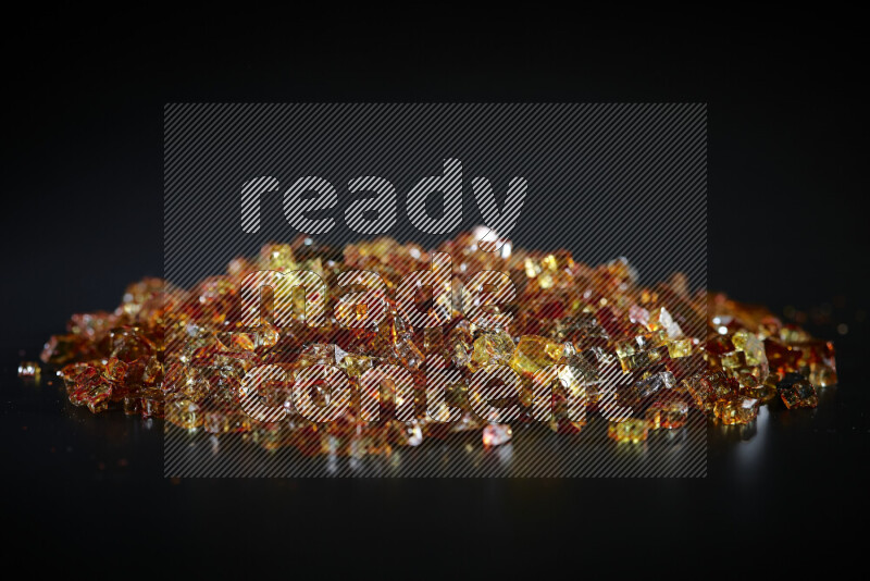 قطع زجاج برتقالية شفافة متناثرة على خلفية سوداء