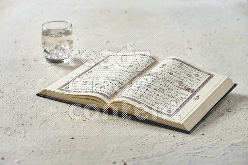 Quran with dates, prayer beads and different drinks on textured white background