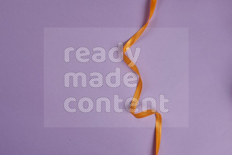 مجموعة من أدوات الخياطة والتفصيل برتقالية اللون على خلفية أرجوانية